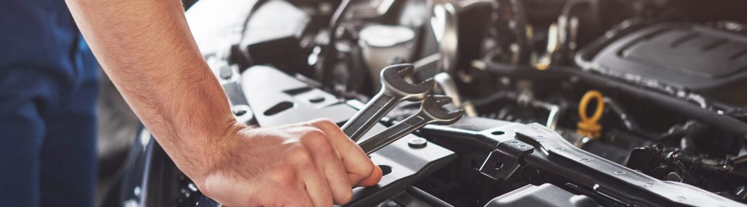 Picture showing muscular car service worker repairing vehicle.